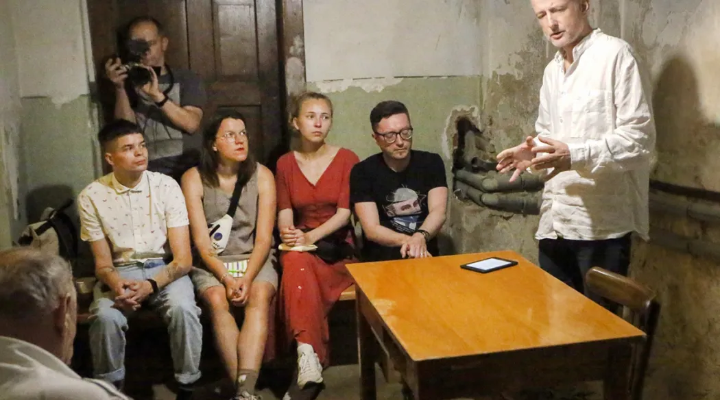 mężczyzna przemawia w schronie do zgromadzonej publiczności