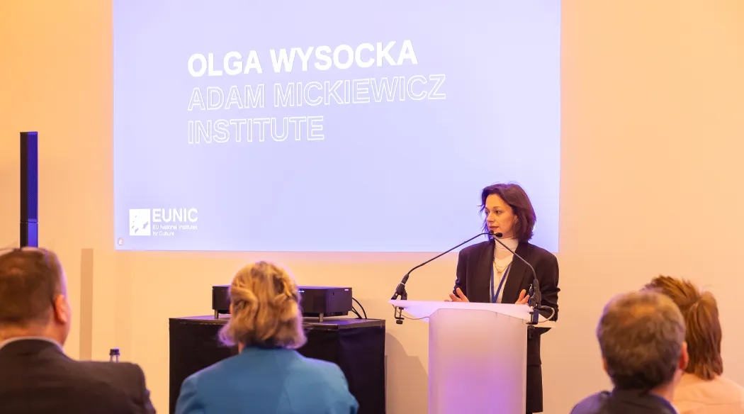 olga wysocka przemawia przy pulpicie przed zgromadzoną publicznością