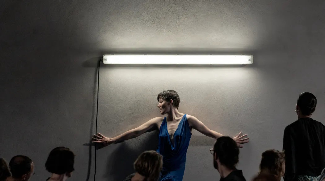 Performerka opierająca się o ścianę
