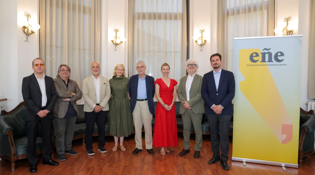 Osiem osób stojących w rzędzie przed roll-upem z napisem "Festiwal Ene"