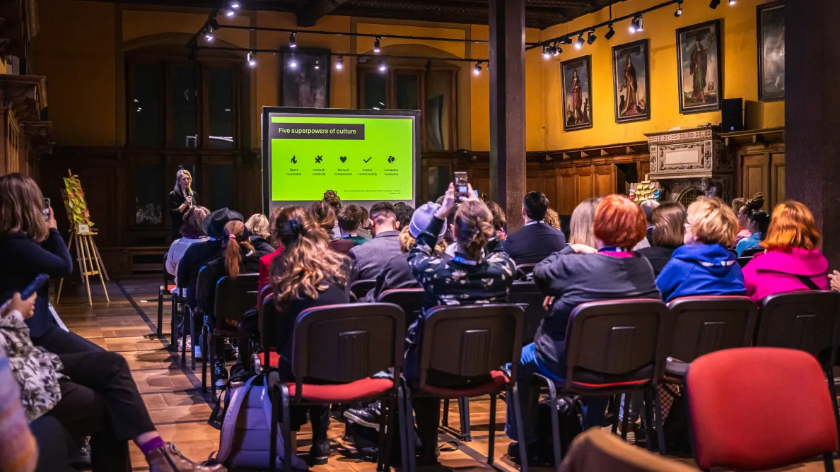 ludzie siedzący w sali słuchają wykładu 