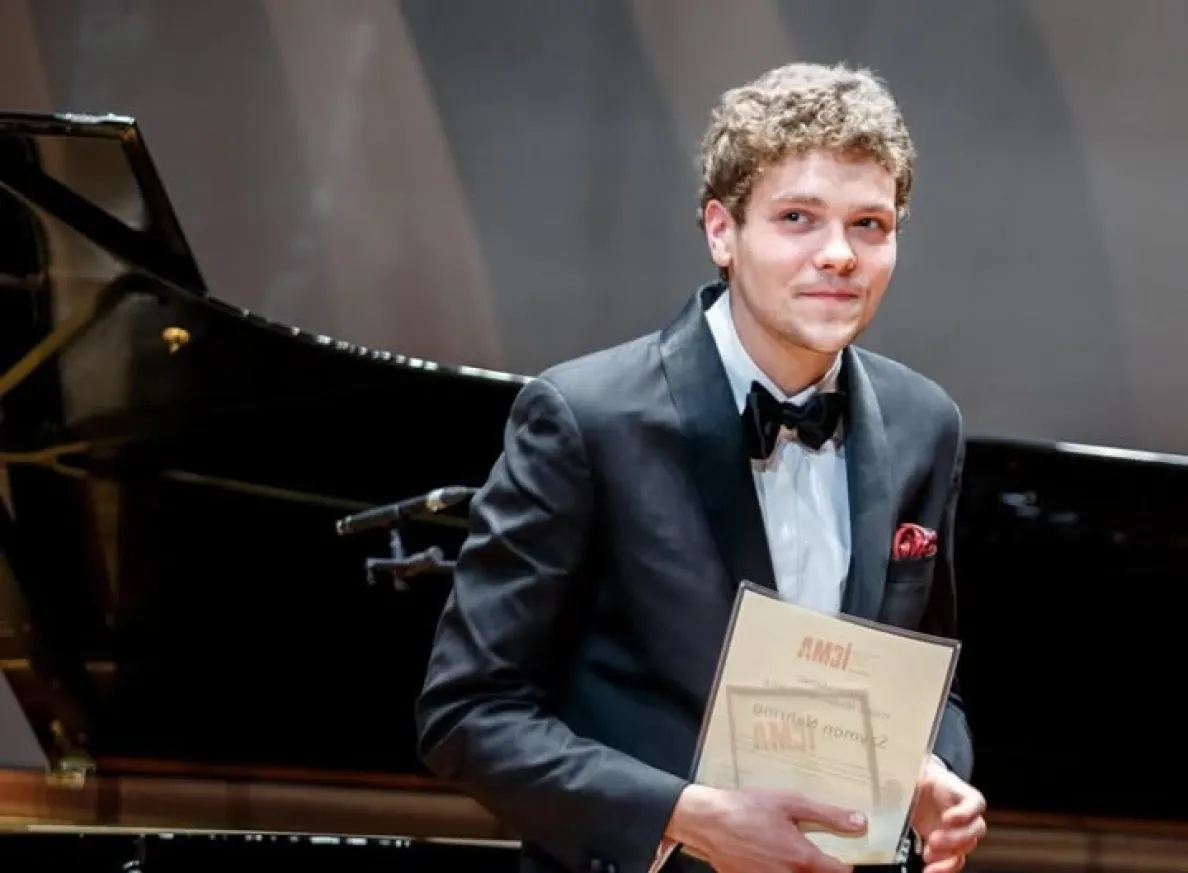 Nehring pozuje przy fortepianie