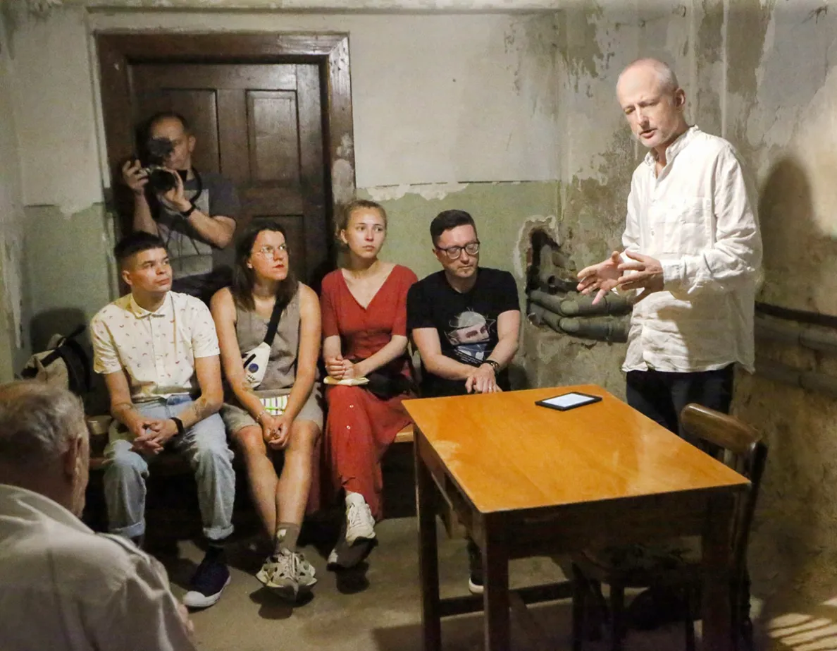 mężczyzna przemawia w schronie do zgromadzonej publiczności