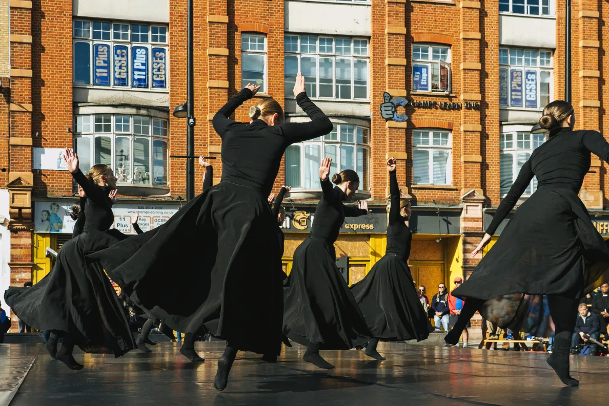 kobiety w czarnych sukienkach wirujące na scenie