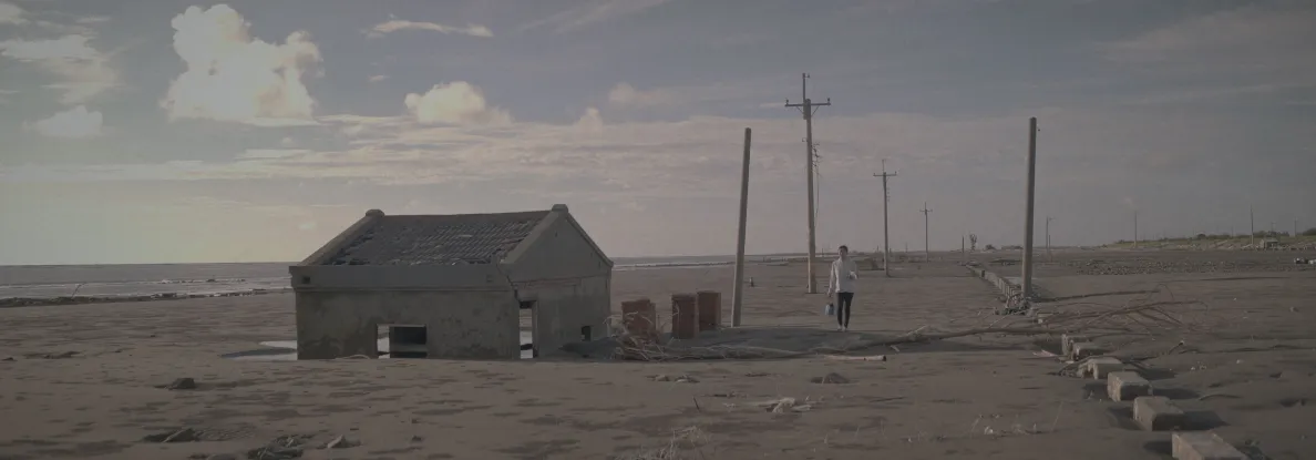 kadr z filmu pokazujący dom na plaży zasypany przez piasek