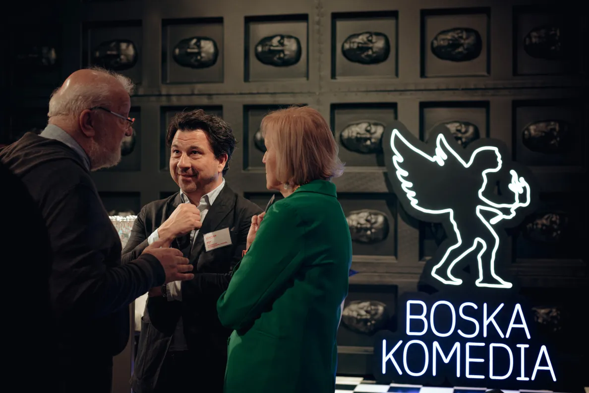 ludzie rozmawiający podczas spotkania, obok neon festiwalowy