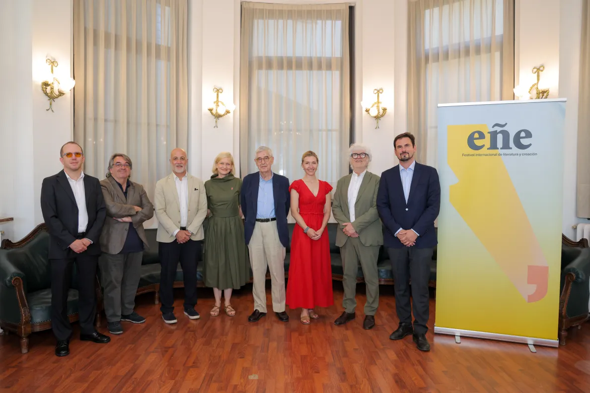 Osiem osób stojących w rzędzie przed roll-upem z napisem "Festiwal Ene"