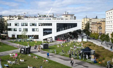 budynek - siedziba FPFF, przed nim błonia zastawione leżakami i strefą rekreacyjna