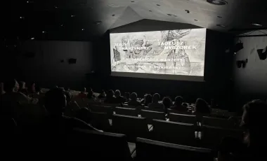 czarno-biały film wyświetlany w sali kinowej, widoczne napisy 