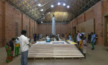 instalacja artystyczna we wnętrzu ceglanej sali, widocznych wielu gości wernisażu