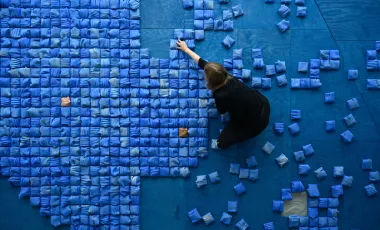 artystka na przygotowanym podłożu układa płytki ceramiczne które złożą się na instalację ripple effect