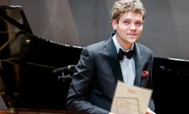 Nehring pozuje przy fortepianie