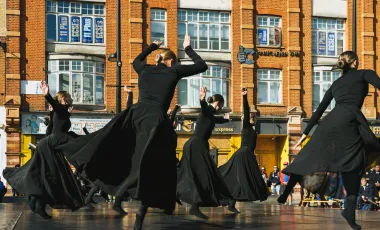 kobiety w czarnych sukienkach wirujące na scenie