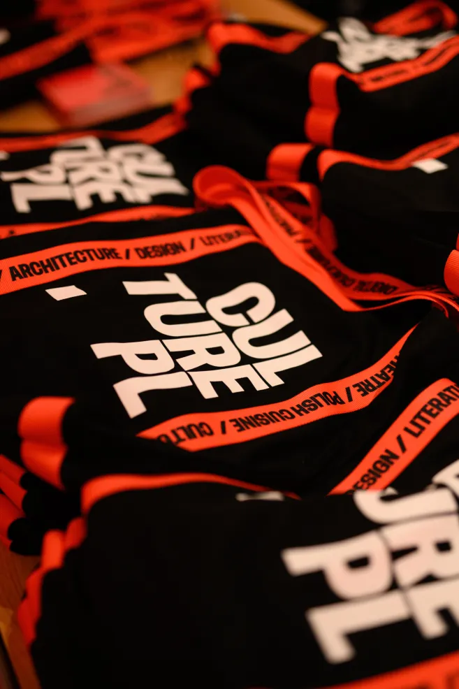 Czarne płócienne torby z białym logo Culture.pl i czerwonymi taśmami