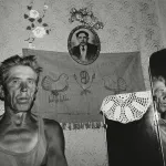 starszy, szczupły mężczyzna stoi w swoim mieszkaniu