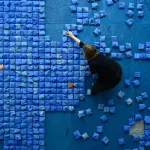 artystka na przygotowanym podłożu układa płytki ceramiczne które złożą się na instalację ripple effect