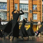 kobiety w czarnych sukienkach wirujące na scenie