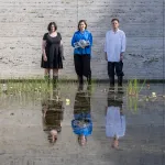 Trzy osoby stojące w sadzawce z liliami wodnymi