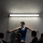 Performerka opierająca się o ścianę