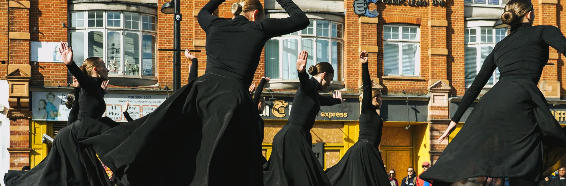 kobiety w czarnych sukienkach wirujące na scenie