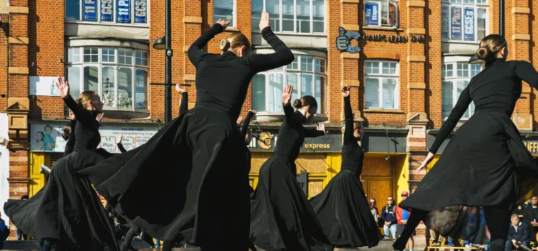 kobiety w czarnych sukienkach wirujące na scenie