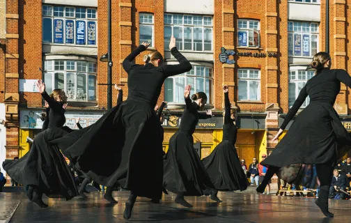 kobiety w czarnych sukienkach wirujące na scenie